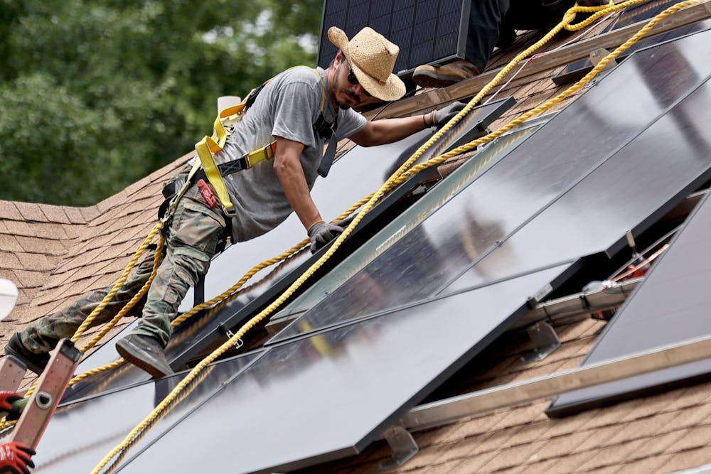 <p>Alternative Energy Southeast employee Aaron Basto installs 18 solar panels to the roof of a residence June 7, 2022, in Ellenwood, Georgia. The City of Bloomington has two programs helping homes, nonprofit organizations and small businesses within city limits transition to using solar energy in 2023.</p>