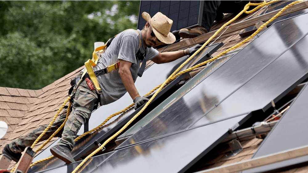 Alternative Energy Southeast employee Aaron Basto installs 18 solar panels to the roof of a residence June 7, 2022, in Ellenwood, Georgia. The City of Bloomington has two programs helping homes, nonprofit organizations and small businesses within city limits transition to using solar energy in 2023.