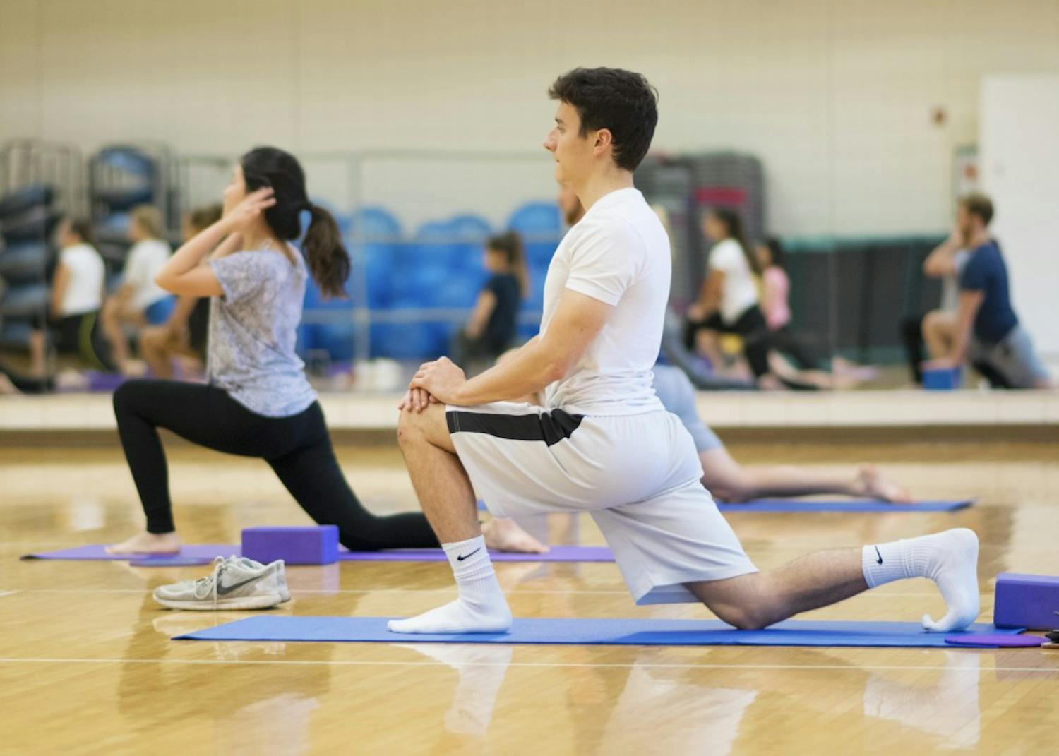 Junior Zach Geremia stretches in a yoga pose at the Bro Flow Yoga-60 session on Oct. 4. Men and women can participate in the yoga practice, which is geared towards athletes.&nbsp;