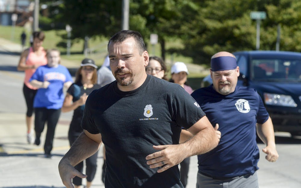 Bloomington Police Department officer Mick Williams and Captain Steven Kellams return from their jogging warmup during the crossfit with a cop event Saturday morning at Hoosier Crossfit. Officers from both the Bloomington Police Department and the Indiana University Police Department came out to bond with citizens and IU students through intensive crossfit exercises.