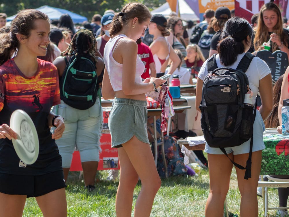 IU junior Hallie Schmecker holds a frisbee in front of the Indiana University Ultimate Frisbee Team both at the Involvement Fair Aug. 26, 2021, in Dunn Meadow. The team travels to compete across the United States each year, according to the group&#x27;s beINvolved page.