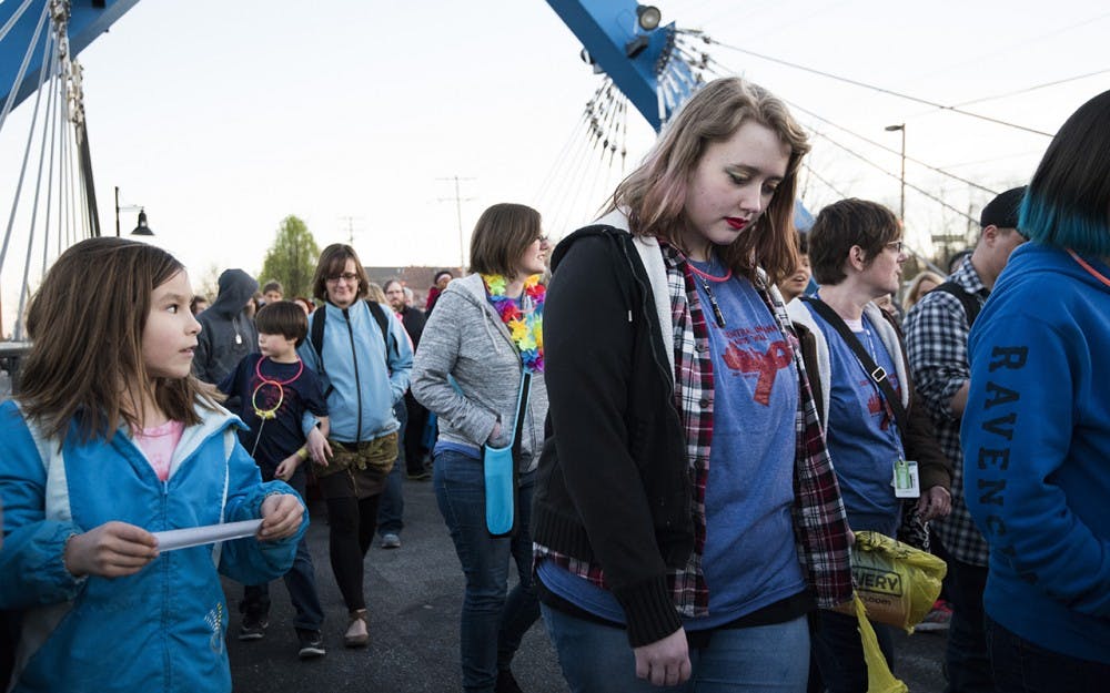 Students in the Prism youth group, families, and other members of the Bloomington community walk down the B-Line Trail Friday night. The AIDS walk was to benefit Positive Link family services for victims of AIDS. 