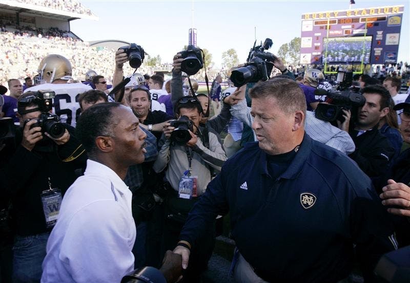 In this Sept. 24, 2005, file photo, Washington coach Tyrone Willingham, left, and Notre Dame coach Charlie Weis shake hands after an NCAA college football game in Seattle. Notre Dame won 36-17. Just like three years ago, Weis is playing down any added pressure from facing Willingham, his predecessor, on Saturday. This time, though, it's a little more believable. 