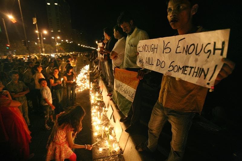 Residents of Mumbai hold a candle light ceremony and a protest on Sunday after attacks on the city killed at least 174 people. The death toll was revised down Sunday from 195 after authorities said some bodies were counted twice, but they said it could rise again as areas of the Taj Mahal were still being searched. Among the dead were 18 foreigners, including six Americans. Nine gunmen were killed. 