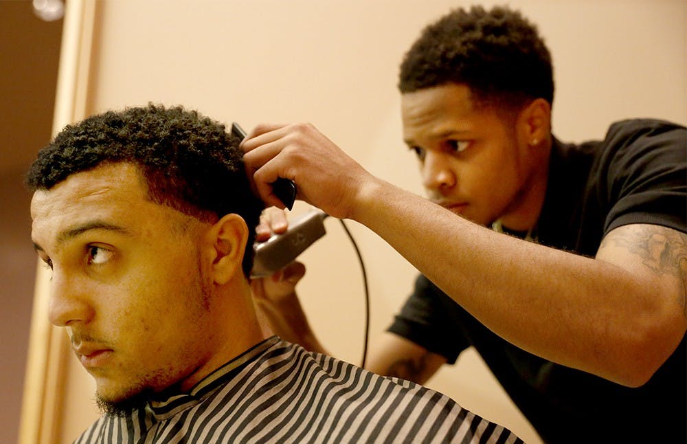 Darryl Rogers, right, cuts junior James Hershberger's hair Tuesday at the Neal-Marshall Black Culture Center. Kappa Alpha Psi hosted the event to address minority issues on the campus and provide a haircut service. 