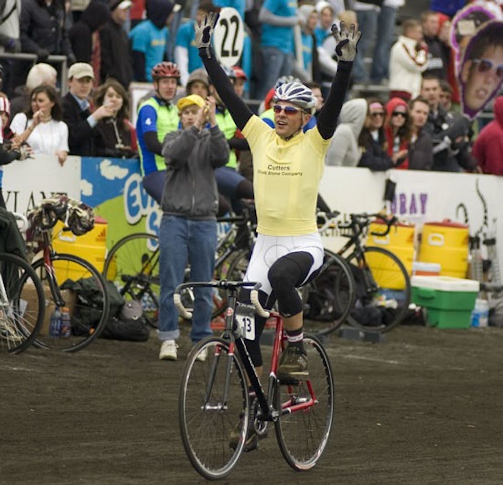 Cutters rider Sasha Land celebrates as he pulls his bicycle into the team pits following the men's Little 500 race Saturday at Bill Armstrong Stadium. Land and Cutters head coach Jim Kirkham were arrested for battery hours after the victory when the two got into an altercation with an employee of Nick’s English Hut.