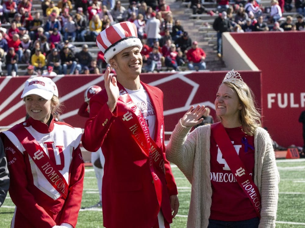 Seniors Adam Day, center, and Hayley Kwasniewski, right, wave after being crowned homecoming king and queen Oct. 13 during IU's game against Iowa at Memorial Stadium. IU lost to Iowa, 42-16.