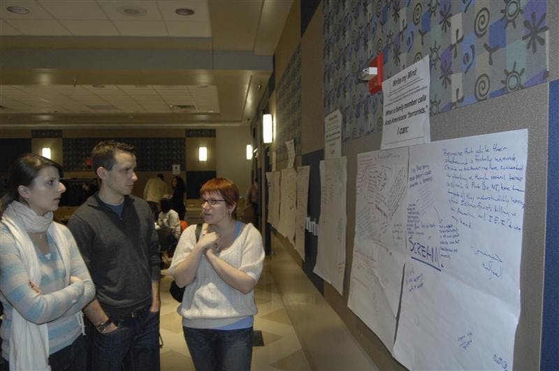 Participants gather around the "Write My Mind" poster where they were asked to write responses to situations that dealt with certain isseus surrounding race, religion and sexual orientation, Monday afternoon at the Willkie Auditorium. The Office of Diversity Education hosted the annual Unity Summit program which focuses on themes of diversity and unity. 
