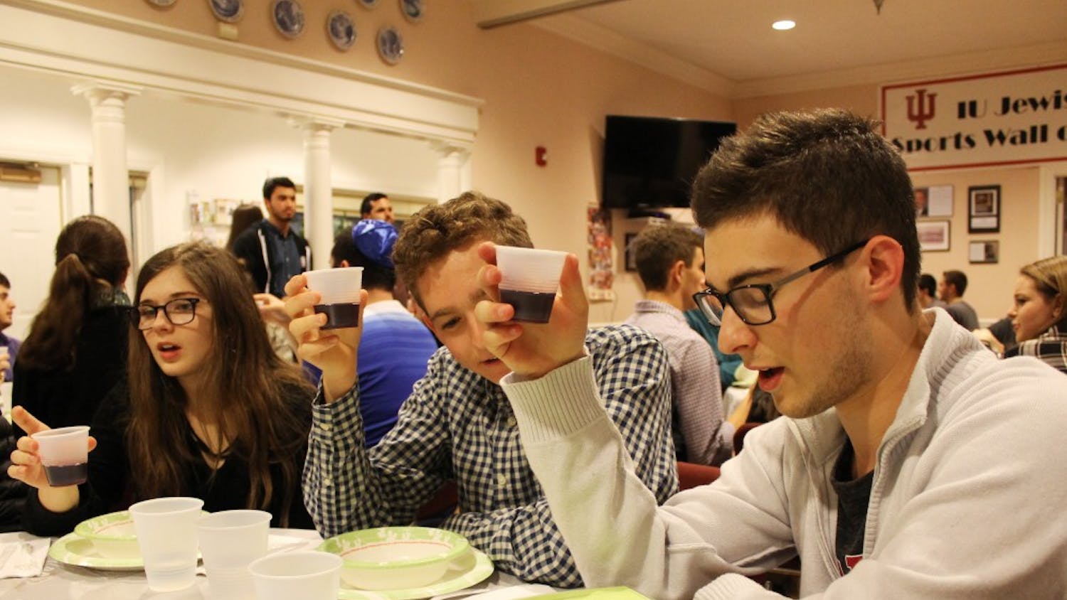 IU students Olivia Turi, Evan Weis and Max Gruenberg raise cups of grape juice during a pre-meal blessing in January 2017 at the Helene G. Simon Hillel Canter. Hillel is one of the many religious organizations on campus.