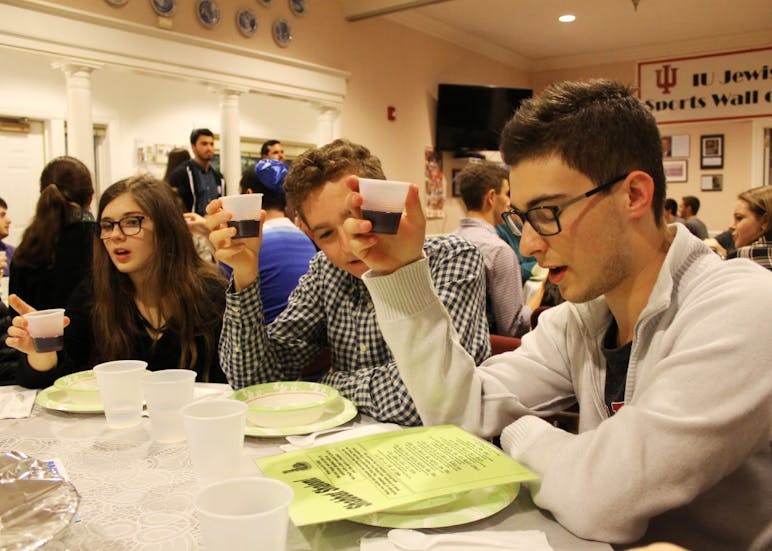 IU students Olivia Turi, Evan Weis and Max Gruenberg raise cups of grape juice during a pre-meal blessing in January 2017 at the Helene G. Simon Hillel Canter. Hillel is one of the many religious organizations on campus.