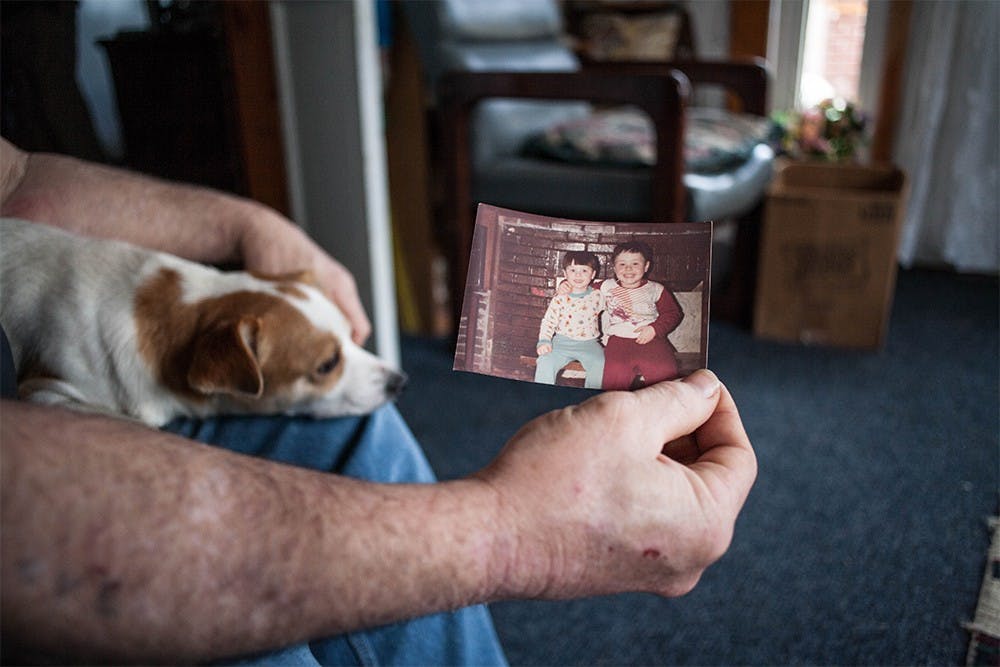 Doug Wagers holds a childhood photograph of his two sons Kyle and Justin Wagers. His dog DD lays on his lap at his parent’s home on Saturday in Trafalger, Indiana. “It’s just a shock. I’m dumbfounded. I’m trying to just figure out why Justin, but the damage is done.” 