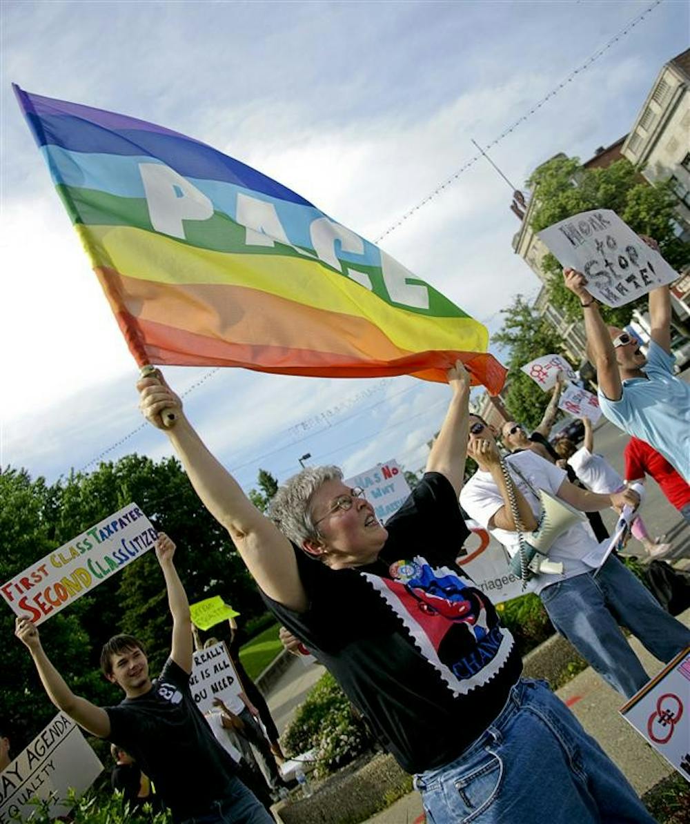 Bloomington resident Linda Zambanini waves a flag Tuesday afternoon outside the Monroe County Courthouse. Protestors gathered to speak against the recent decision of the courts in California to uphold Proposition 8, banning same-sex marriages, but allowing the 18,000 marriages that occured prior to Prop 8's passing to be legally recognized.