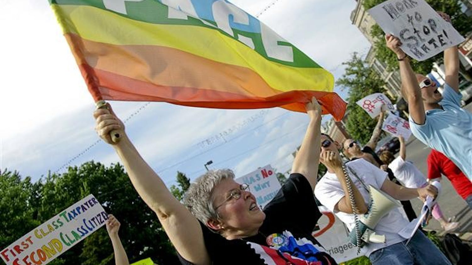 Bloomington resident Linda Zambanini waves a flag Tuesday afternoon outside the Monroe County Courthouse. Protestors gathered to speak against the recent decision of the courts in California to uphold Proposition 8, banning same-sex marriages, but allowing the 18,000 marriages that occured prior to Prop 8's passing to be legally recognized.
