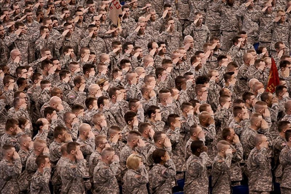 Members of the Army and Indiana National Guard salute the flag Saturday afternoon at Lucas Oil Stadium. A celebration was held to mark the return of many armed servicemen returning from overseas.