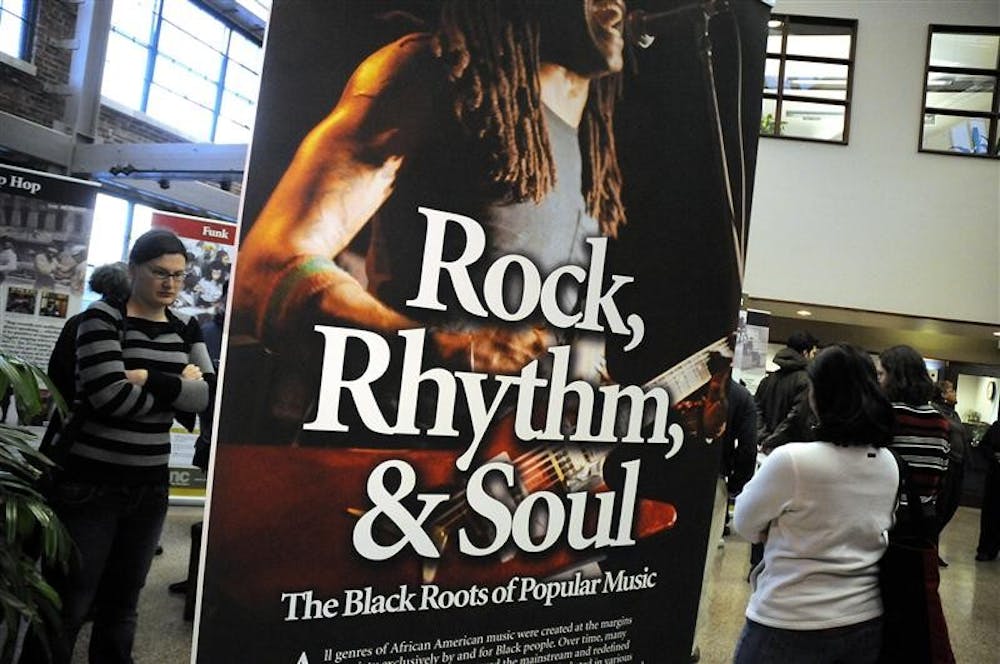 People read banners during the opening reception for "Rock, Rhythm & Soul: The Black Roots of Popular Music" Thursday in the City Hall Showers Building. The traveling exhibit features banners highlighting key points in African American music, and was put together by the IU Archives of African American Music and Culture.