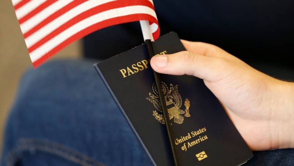 A hand holds a passport. Long visa approval wait times can cause IU students to miss the start dates of their internships and classes.