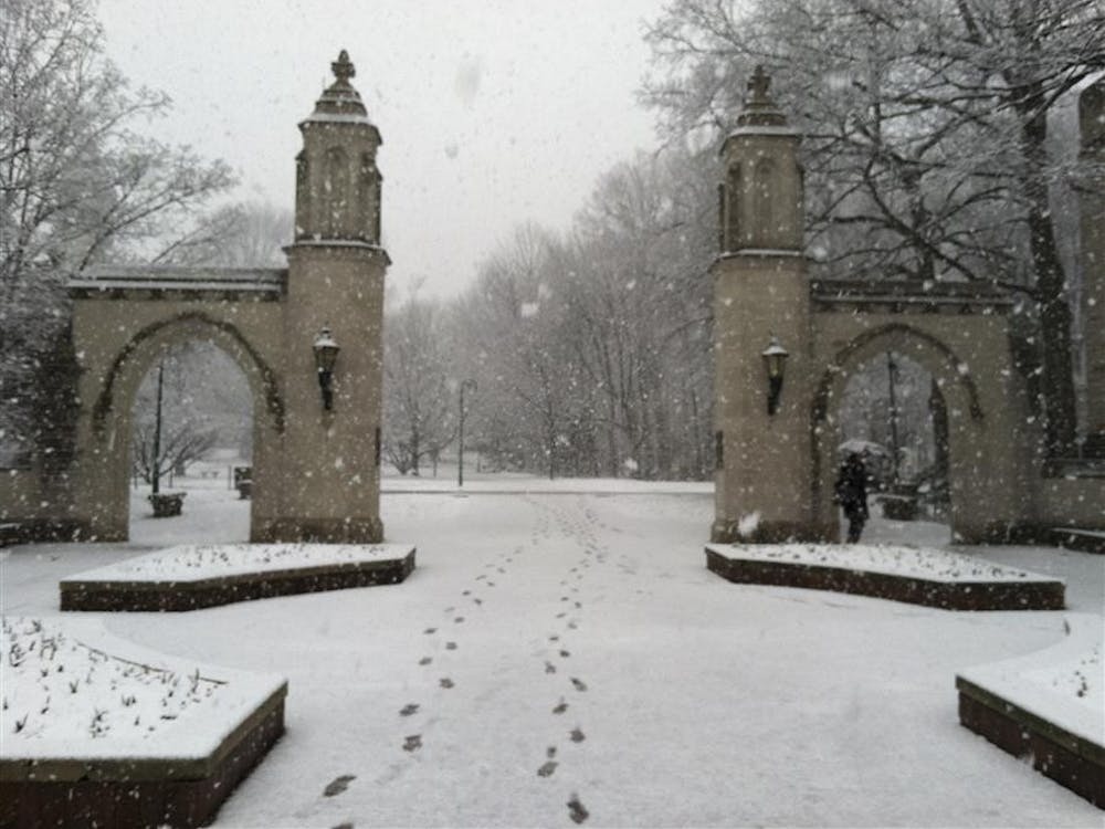 Snow falls over the Sample Gates on Sunday in Bloomington.