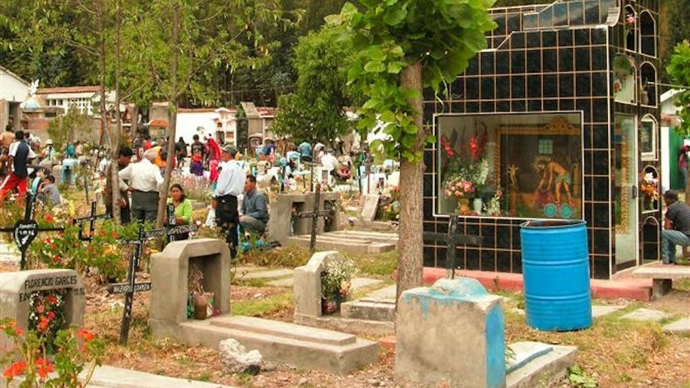 A crowd of vendors and families celebrate outside the entrance to the graveyard "Jardines de la Paz," or "Gardens of Peace," in Calca, Peru, for the Nov. 2 Day of the Dead holiday.