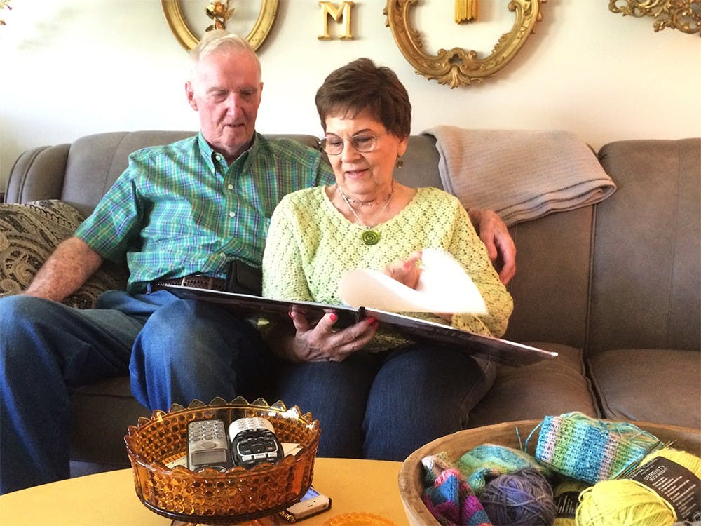Merrill and Madalyn Maxwell sit in their new living room looking over photos of their house that was demolished to make way for I-69.