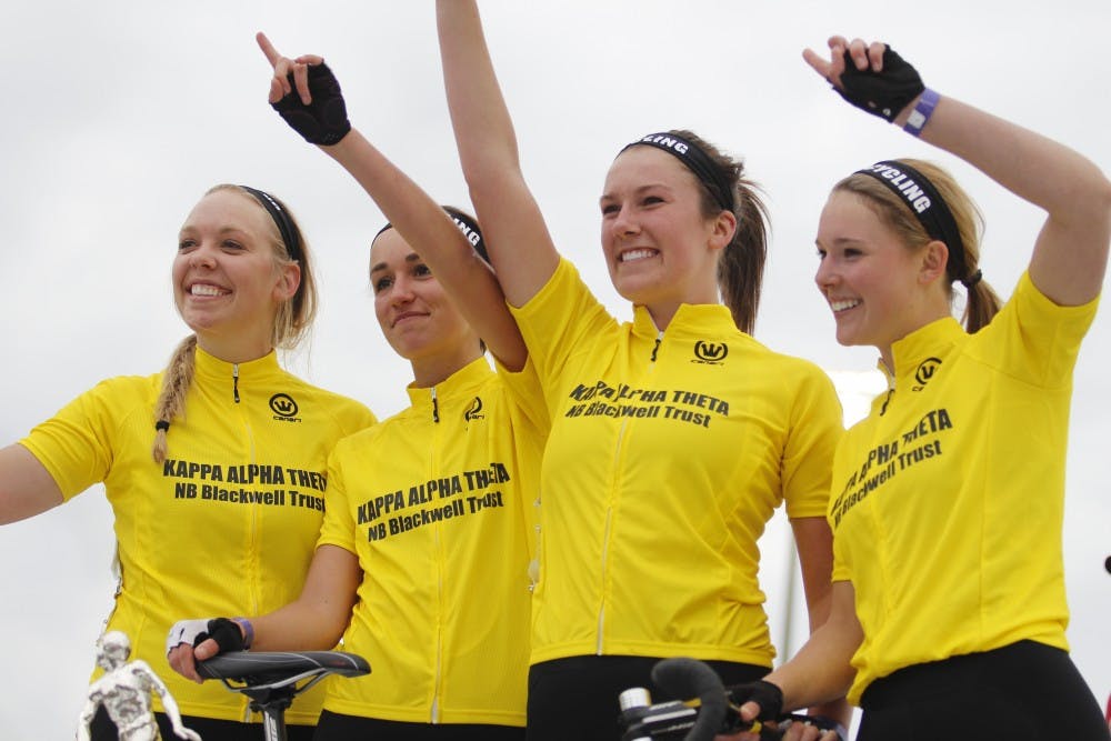 The Kappa Alpha Theta bike team hold their hands up while being announced as the winners of the women's Little 500 in Bill Armstrong Stadium on Friday.