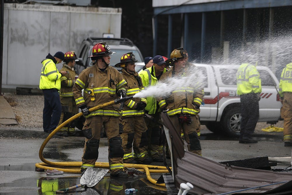 Firefighters spray the back side of the Village Deli where the fire broke out. 