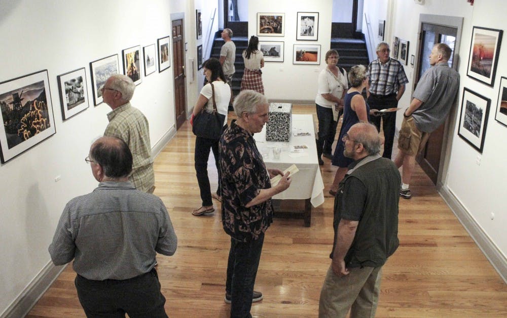 People gather to look at the photos and paintings exhibited on Friday evening at Ivy Tech John Waldron Arts Center. This is part of the Gallery Walk event. 