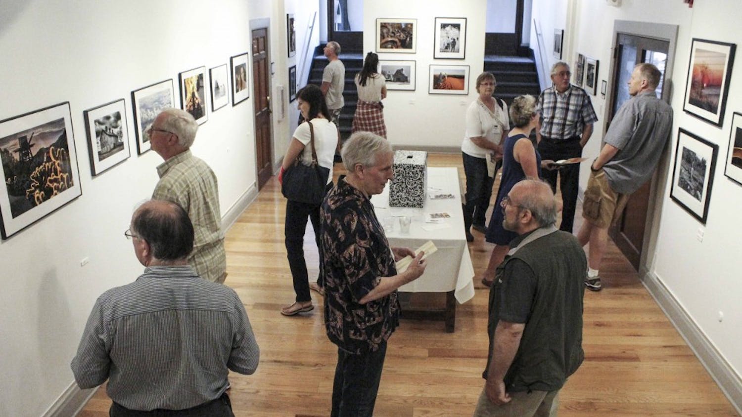 People gather to look at the photos and paintings exhibited on Friday evening at Ivy Tech John Waldron Arts Center. This is part of the Gallery Walk event. 