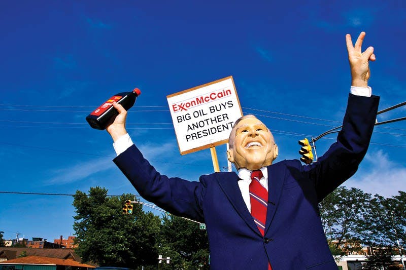 Bloomington resident Steve Mascari, wearing a President George W. Bush mask, along with members of MoveOn.org, protest Wednesday evening at the corner of Rogers Street and Kirkwood Avenue. MoveOn.org was protesting against politicians they believe are responsible for high gas prices.