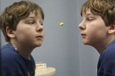 Ezra Robinson, 11, engages himself in the mirror during a speech therapy session. Ezra began exhibiting signs of autism when he was two-years old, and has since been diagnosed in the middle of the autism spectrum. 