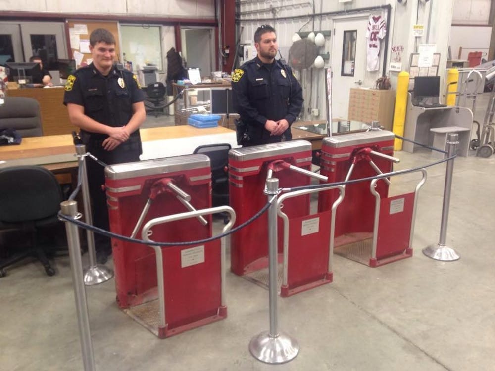 IUPD officers guard tunstiles to prevent crowds touching them at the IU Surplus Store. A historic Assembly Hall turnstiles will be auctioned off this month. 