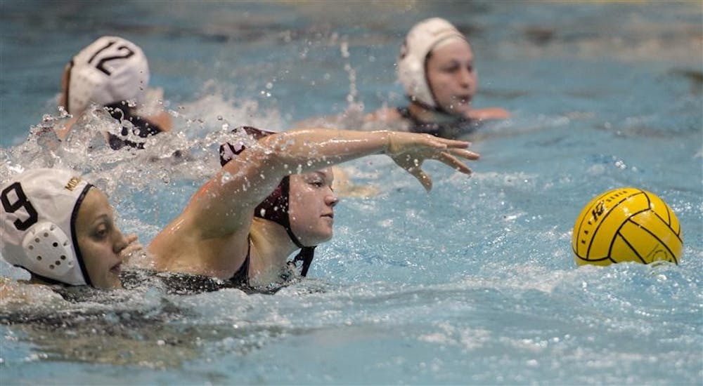 IU utility player Rebecca Gerrity reaches for the ball during the Fluid Four tournament between IU and Michigan Feb. 23 at the Counsilman-Billingsley Aquatic Center. Hoosiers beat the Wolverines 12-5.