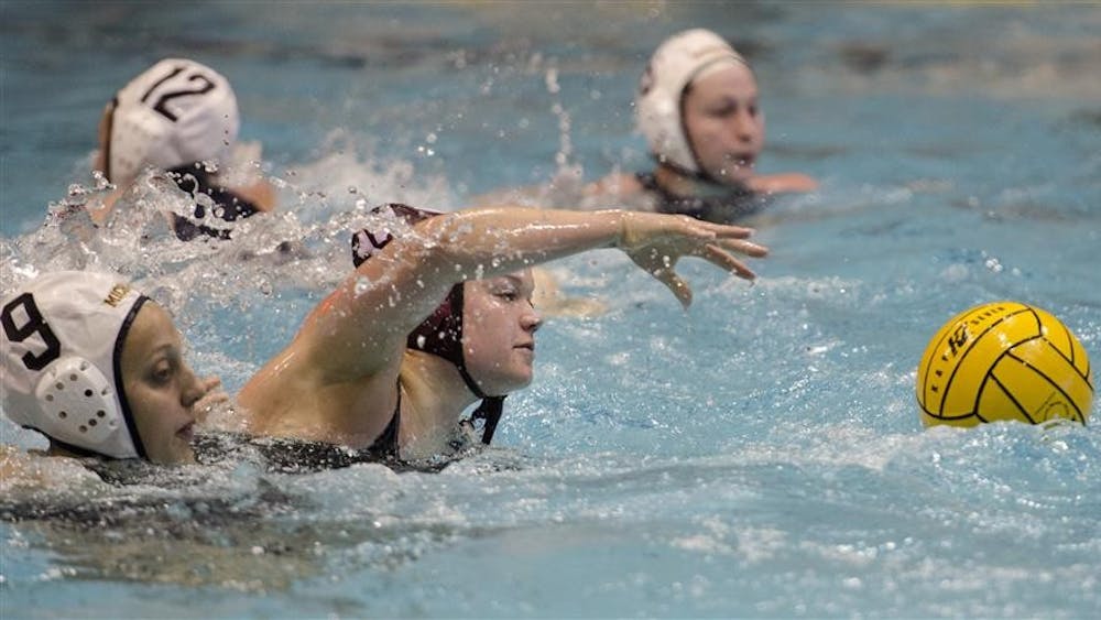 IU utility player Rebecca Gerrity reaches for the ball during the Fluid Four tournament between IU and Michigan Feb. 23 at the Counsilman-Billingsley Aquatic Center. Hoosiers beat the Wolverines 12-5.