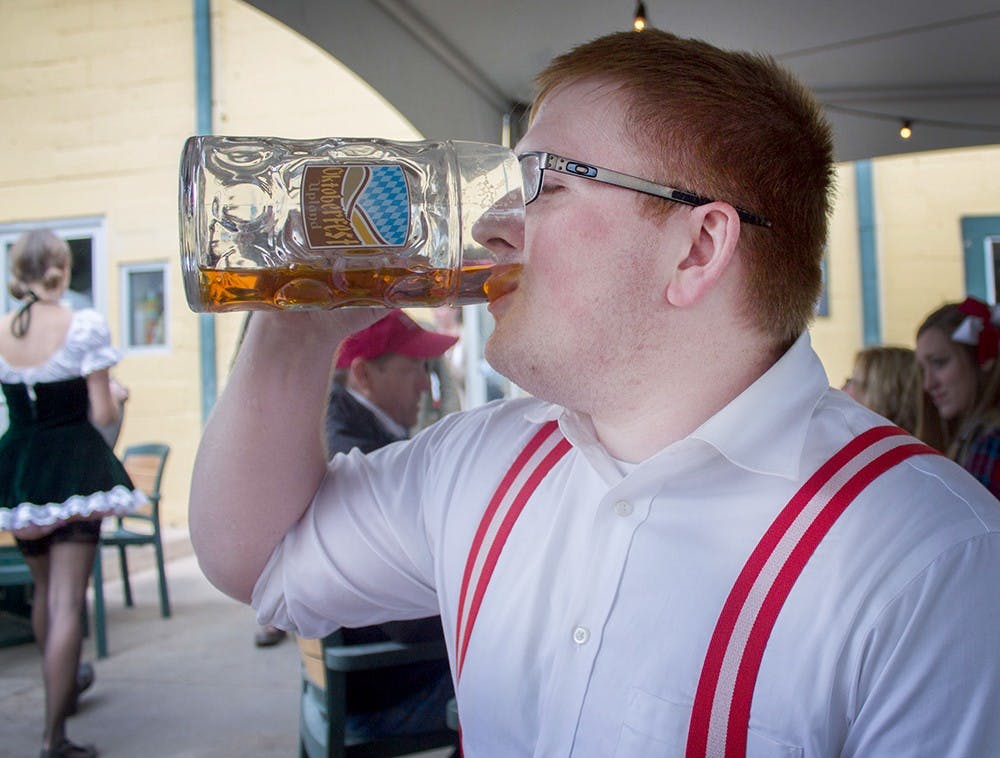 Keenan Hartment drinks beer at the Upland Brewing Company's Oktoberfest event Saturday.