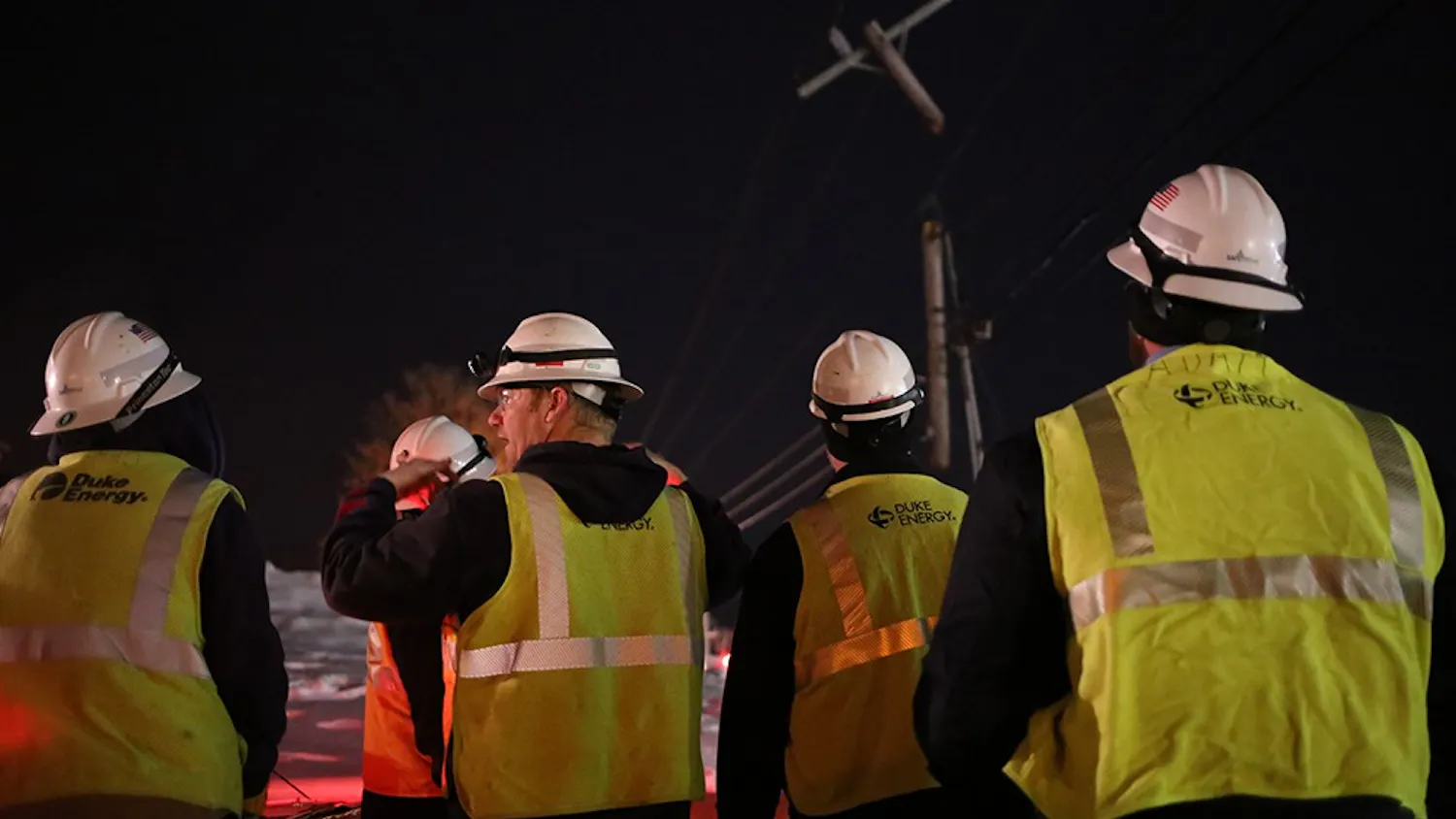 Duke Energy workers plan their coming hours of work on Monday night after a truck crashed into the side of Third Street.