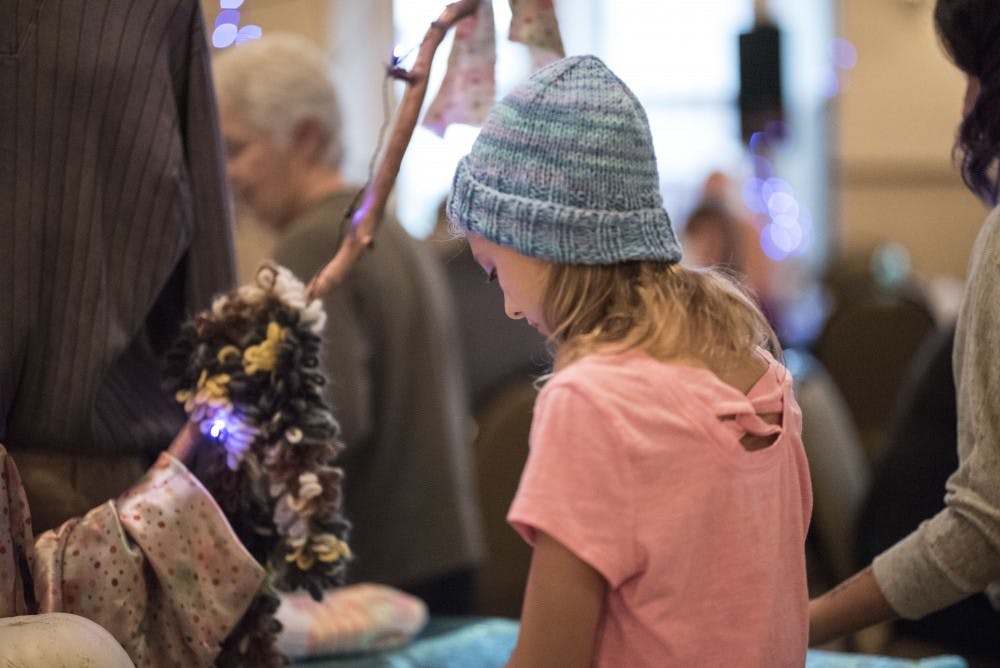 Chloe Senior, 11, looks at hats at Wrapped in Love in the Fountain Square Ballroom on Sunday. The event benefitted Middle Way House, and each attendee was able to choose one hat for participating in the event.
