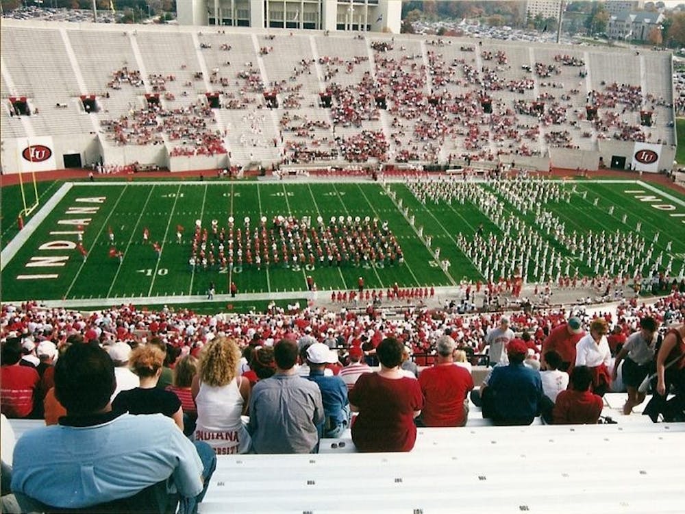 The Marching Hundred Alumni Band (left) performs during IU’s Homecoming with the student Marching Hundred at Memorial Stadium.