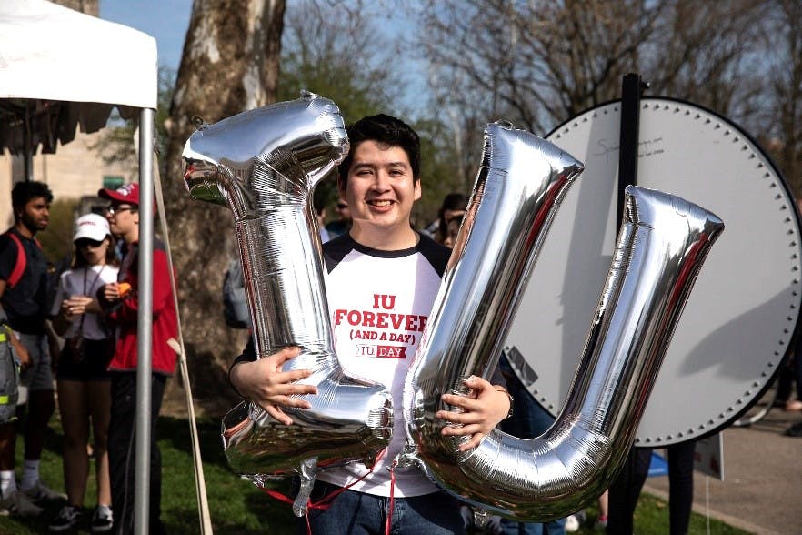 A student poses with IU balloons at the 2019 IU Day Block Party.
