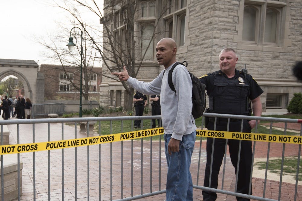 A policeman tells a man to calm down after he yells at the crowd protesting Charles Murray. The man was one of only a few people opposing the protester's viewpoints. 