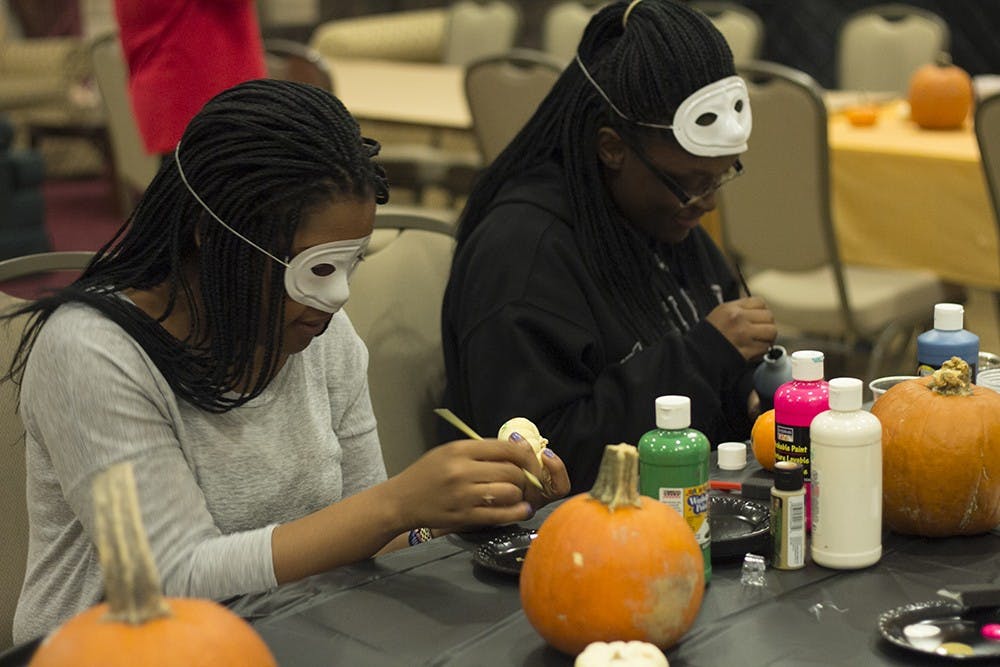 Students wear masks and paint on pumpkins during the Union Board's sponsored event Thursday in the Indiana Memorial Union.