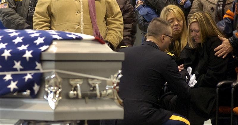 Alison Hernandez, right, is comforted by her mother Billie Meadows, center, and a military representative after the casket carrying her husband, Cpl. Joseph M. Hernandez, arrived by plane at the Indiana National Guard facility at the Gary/Chicago International Airport Thursday in Gary, Ind..  Cpl. Hernandez, of Hammond, Ind., was killed in a roadside bomb attack while serving in Afghanistan.