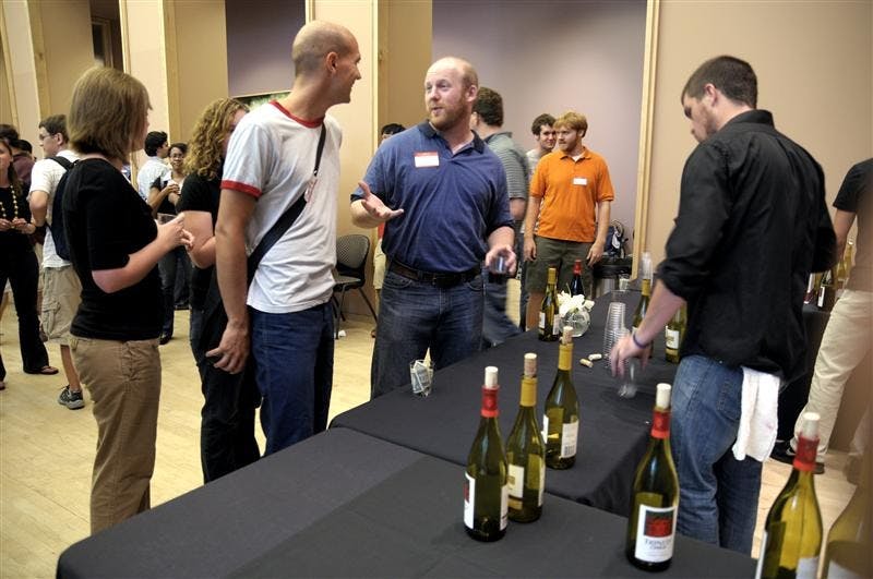 Dan Smith, an employee of Lennie's, serves wine at the University Graduate School reception to welcome back new and returning graduate students at the Neal-Marshall Center Friday afternoon. Lennie's donated wine and labor to the event.