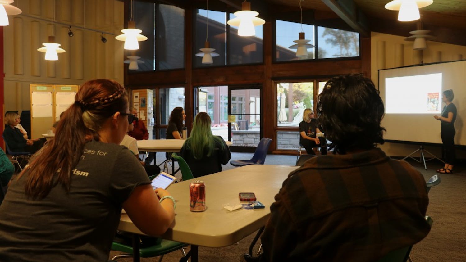 Bloomington community members listen to a presentation on LGBTQ+ History given by Prism Youth Community leaders Tuesday evening. Prism Youth Community is a youth-lead initiative to promote inclusivity.