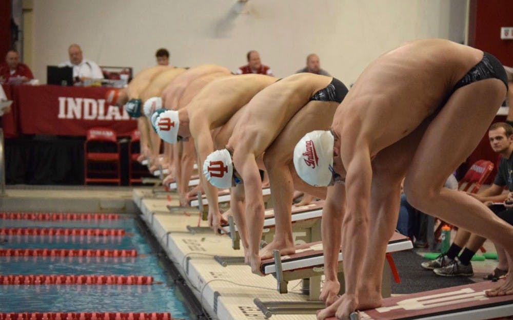 Men's swim teams prepare to begin the 50m freestyle in the timed finals.
