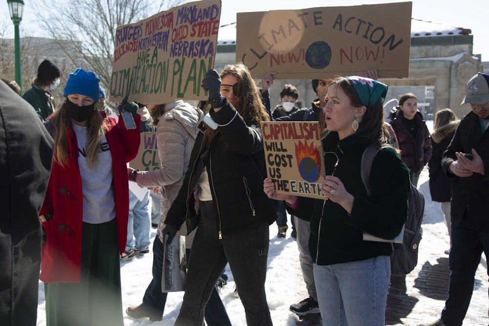 <p>IU senior Abbey Krulik holds a sign that says &quot;Capitalism will cost us the Earth during a rally Feb. 8, 2022, by Sunrise Bloomington calling on the IU Foundation to divest from fossil fuels. Representatives from student climate groups met with IU administration Feb. 9.<br/></p>