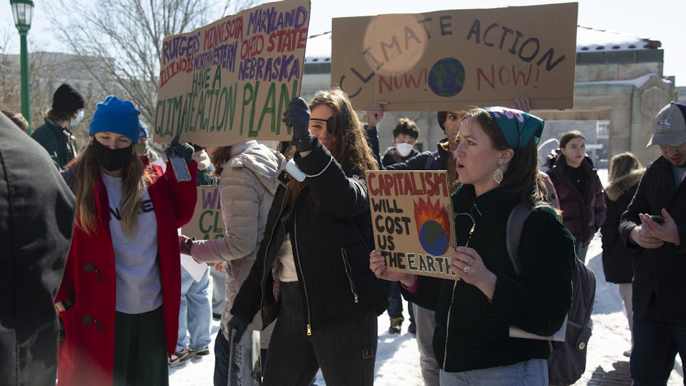 IU senior Abbey Krulik holds a sign that says &quot;Capitalism will cost us the Earth during a rally Feb. 8, 2022, by Sunrise Bloomington calling on the IU Foundation to divest from fossil fuels. Representatives from student climate groups met with IU administration Feb. 9.