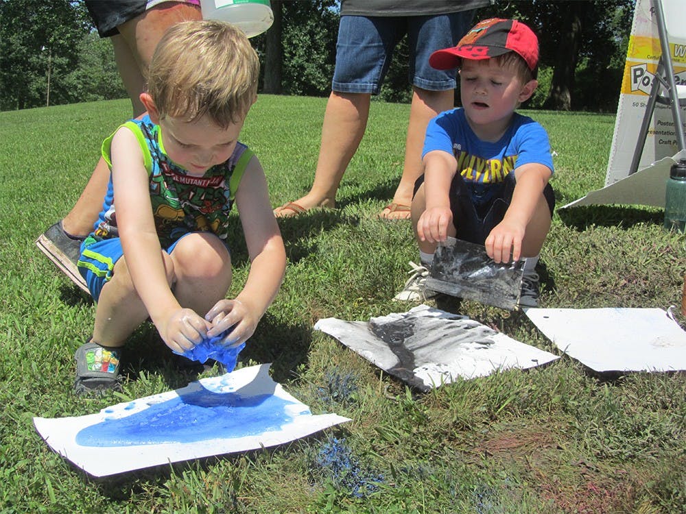 From left, Logan May and Liam Newton participate in a messy crafts activity at the annual event hosted by the Parks and Recreation Department on Tuesday. 