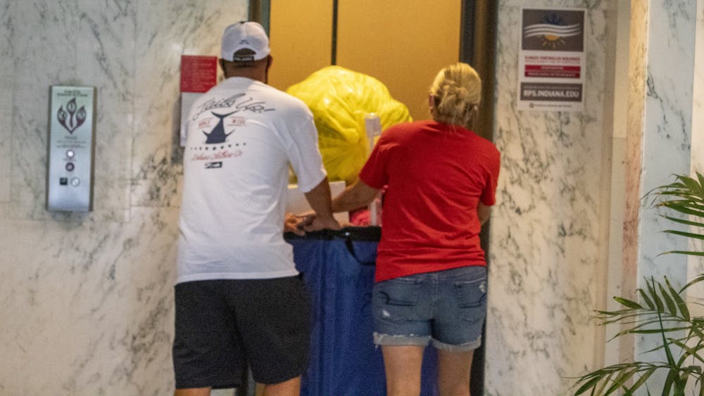 8月18日，在威尔基奎德(Willkie Quad)，搬进来的客人帮助将一辆手推车搬进电梯。所有住在校内宿舍的学生都必须在入学前接受COVID-19检测，并在抵达印第安纳大学后进行额外检测。