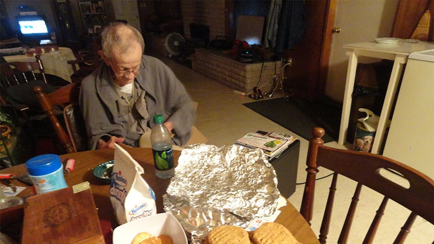 George McNeely thumbs through a dictionary after examining a basket of several dozen peanut butter cookies. The cookies are a family recipe that was originally created by his mother.
