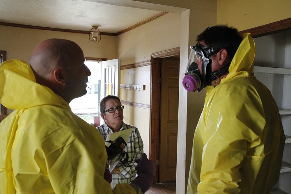 After pulling up to the home in her Jeep, Weaver (left) and Hoke (right) pause from their work to update Rebel Middleton (center), the homeowner on their progress in clearing out and cleaning the house. She plans to rent it out again once it's repaired.