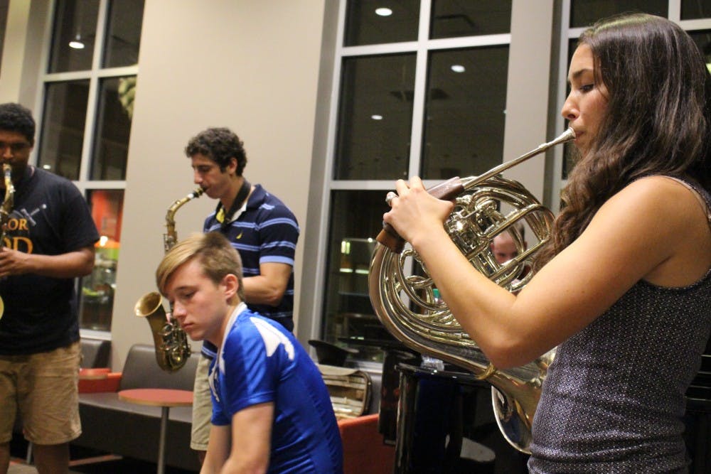 French horn player Olivia Martinez, right, plays with other members of a jazz improvisation group, including Austin Peters, seated. Martinez, a founding member, is a music major, but Peters, new to the group, is a finance major. The group is open to musicians from all backgrounds.
